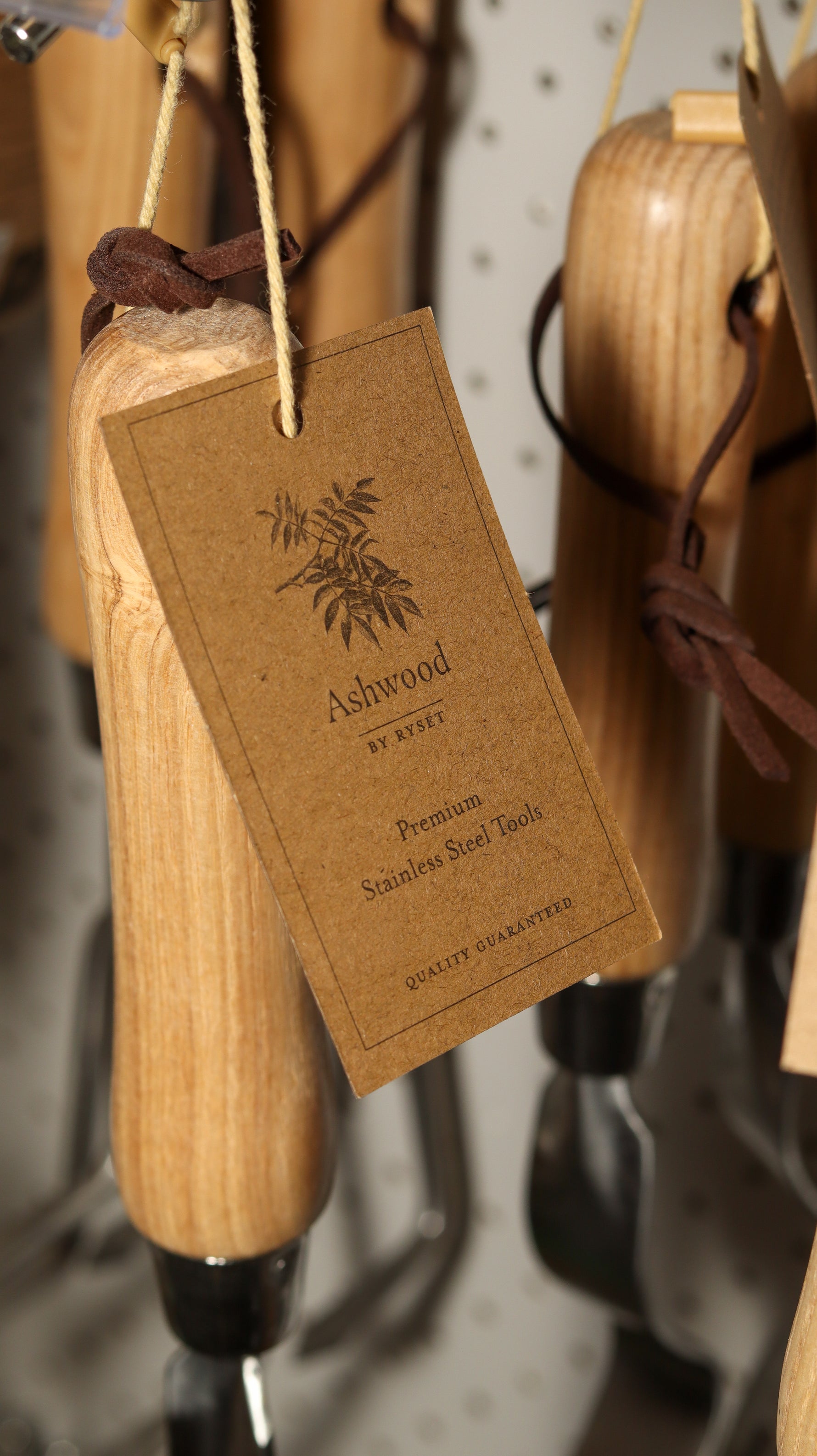 Wooden tool with a 'Ashwood' tag on a pegboard background