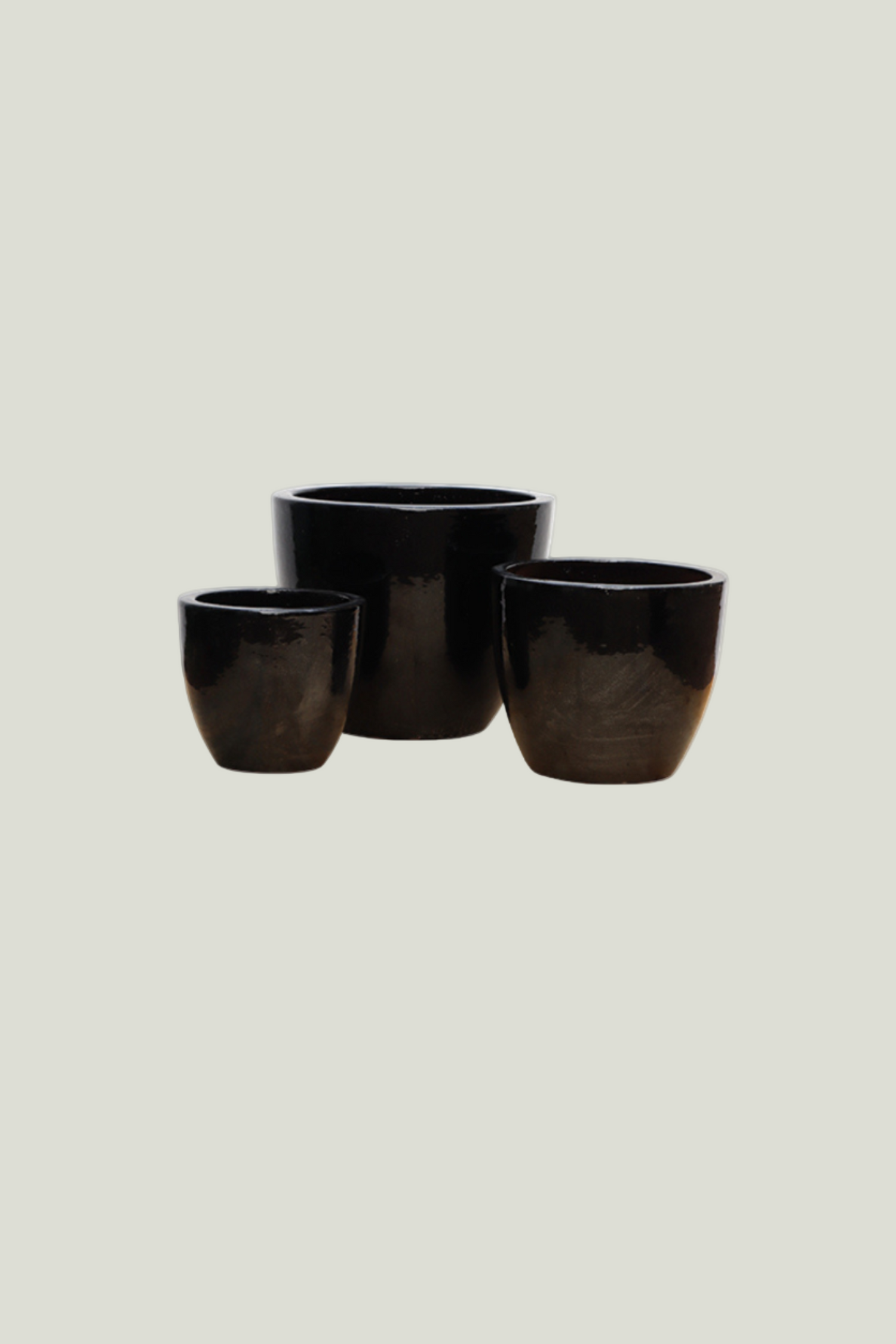 Three black ceramic pots of varying sizes