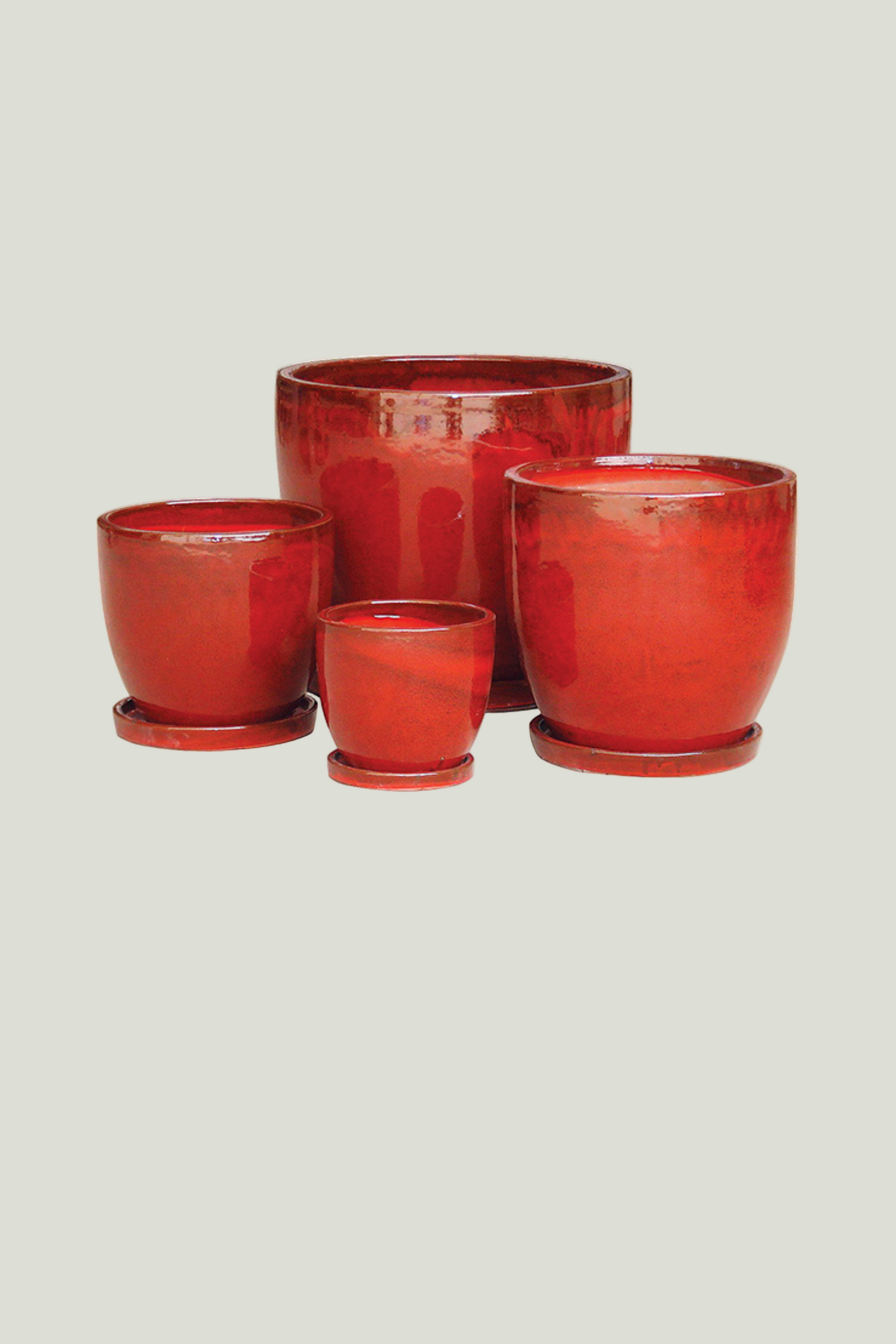 Set of four red ceramic pots with saucers