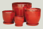 Set of four red ceramic pots with saucers