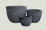 Three gray stone planters of different sizes