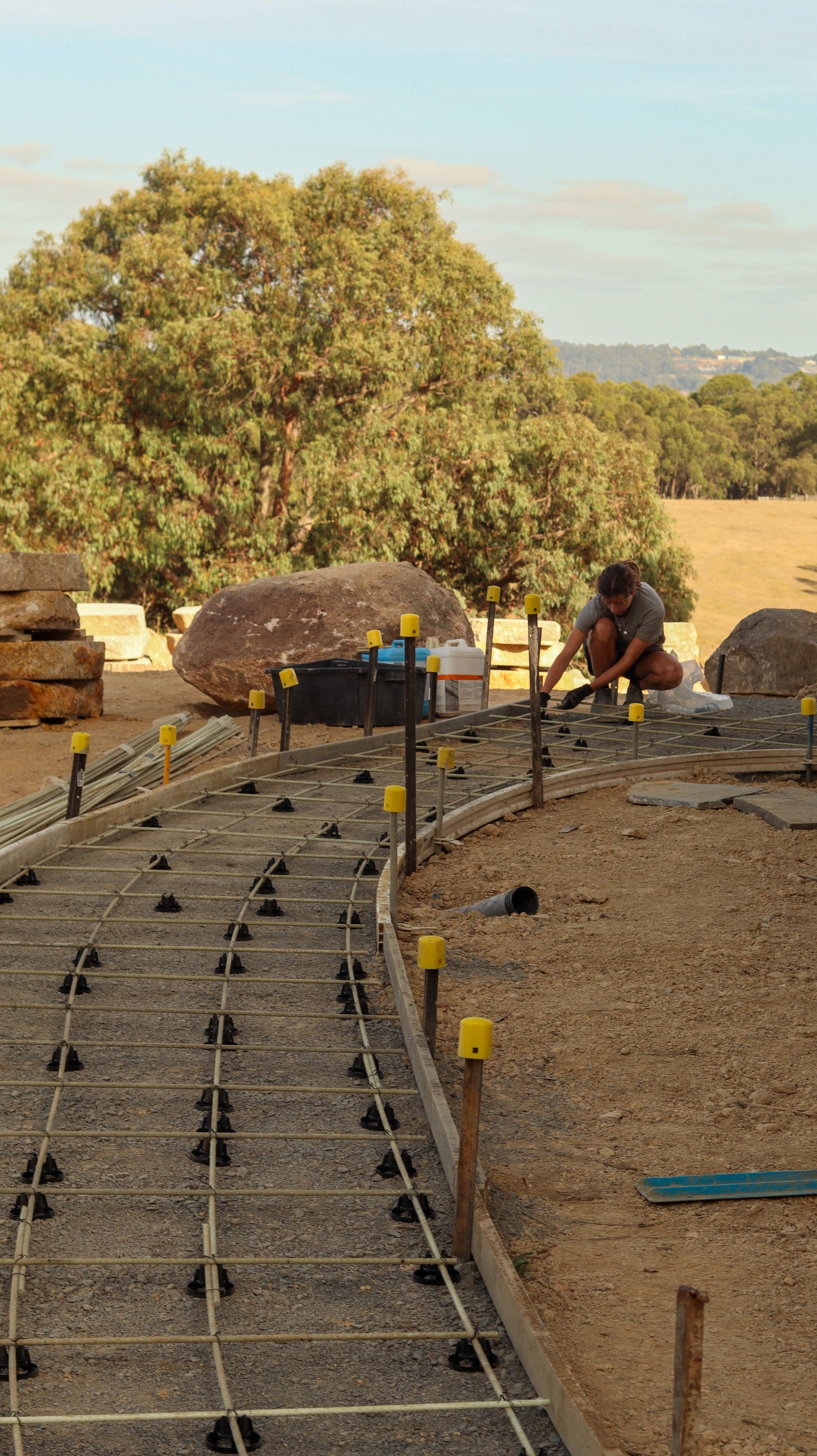 Person installing GFRP reinforcement for a paving slab