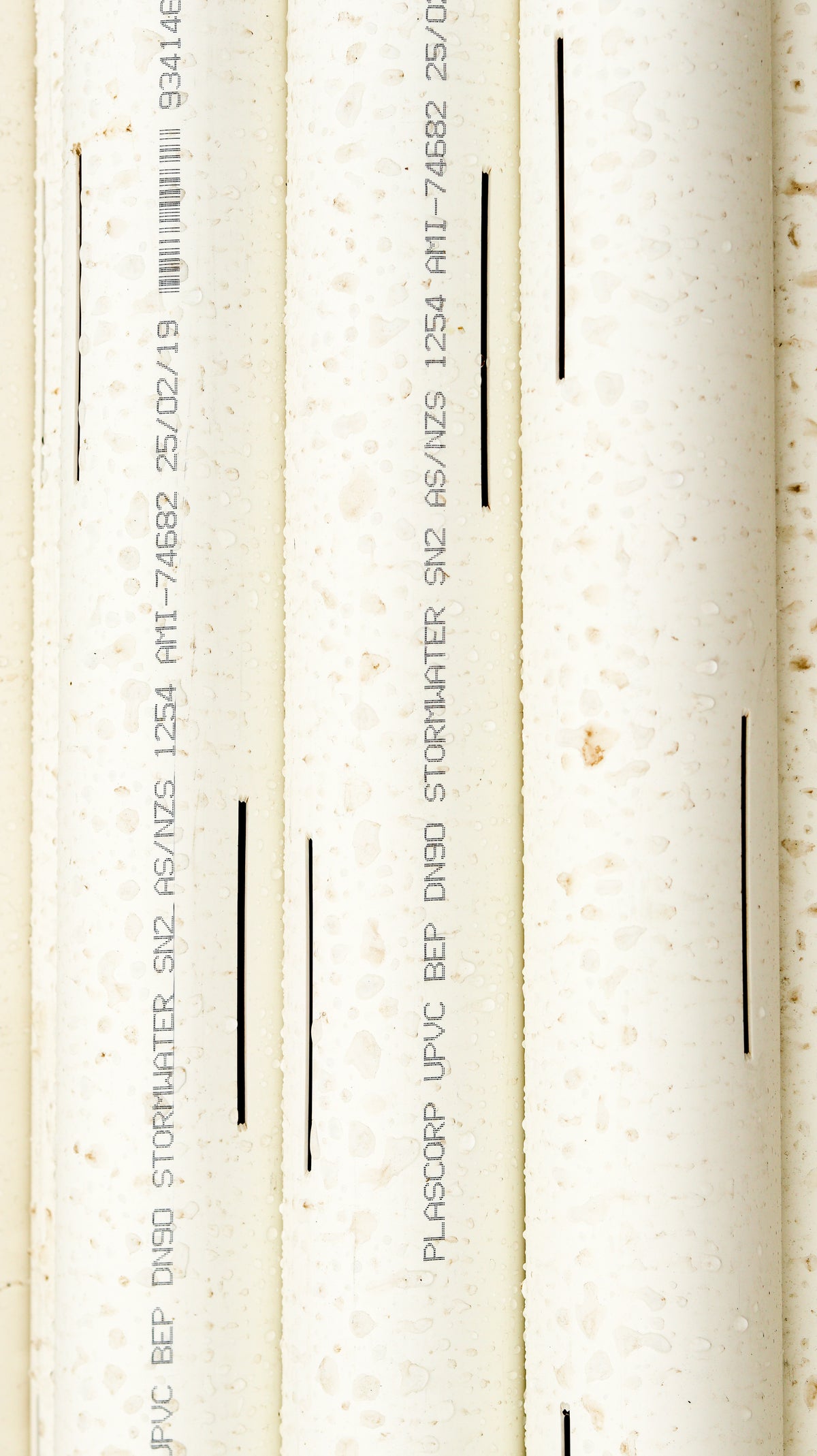 Three white slotted pipes with text 