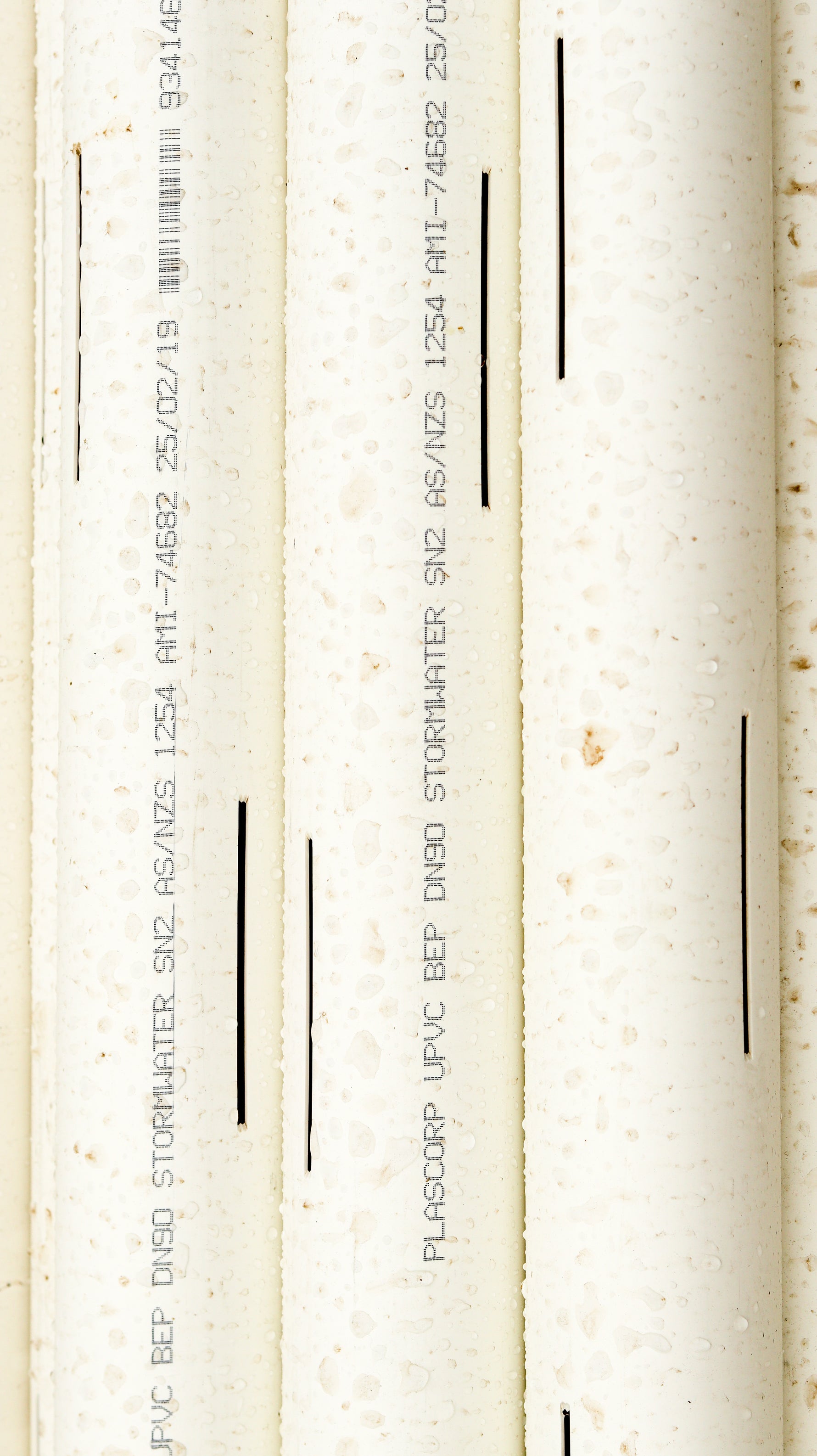 Three white slotted pipes with text 