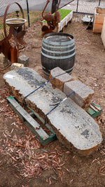 Long stone bench seat on a pallet in an outdoor setting