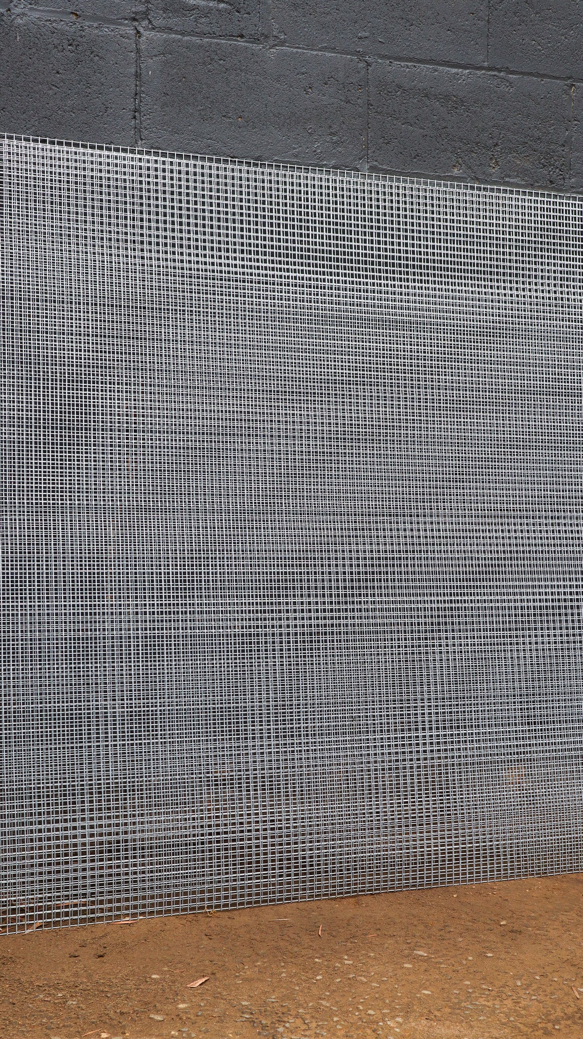 Metal mesh against a concrete wall