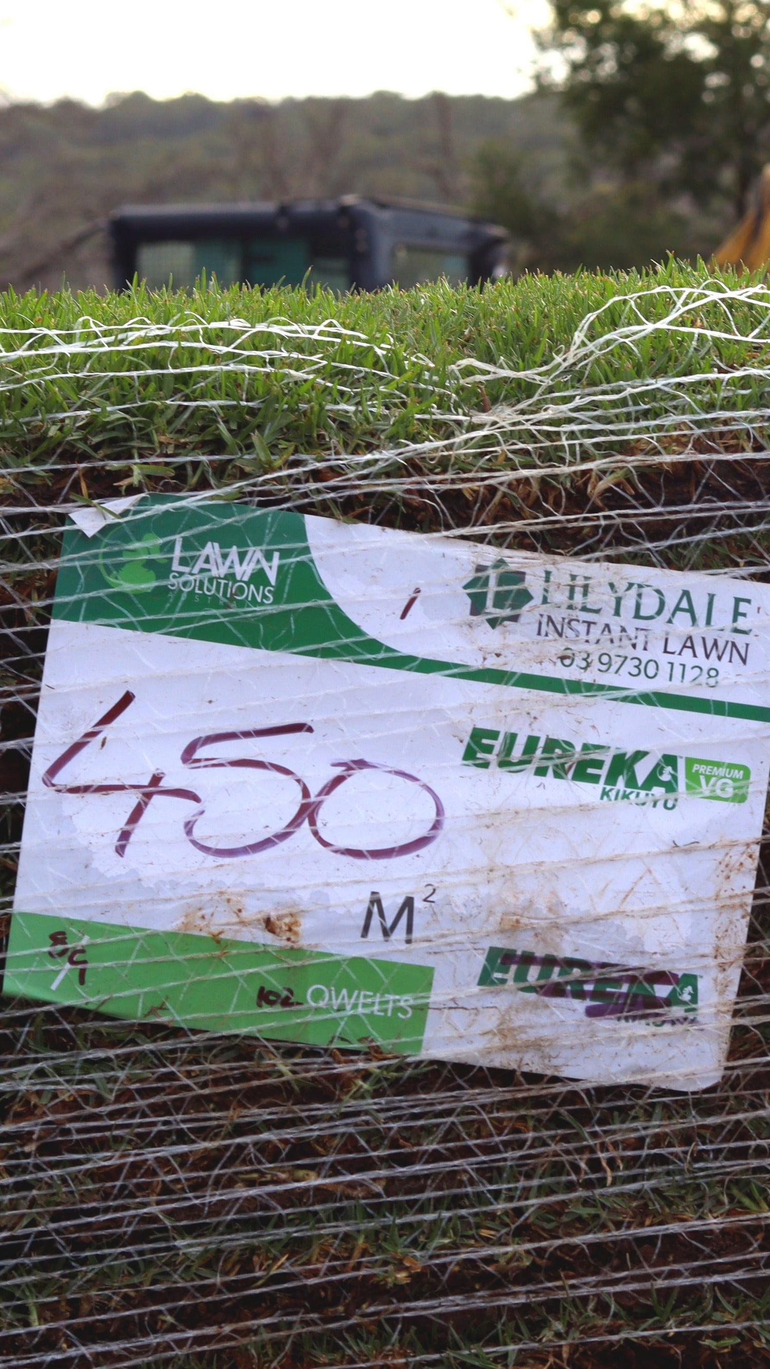 Roll of sod with a label on a grassy background