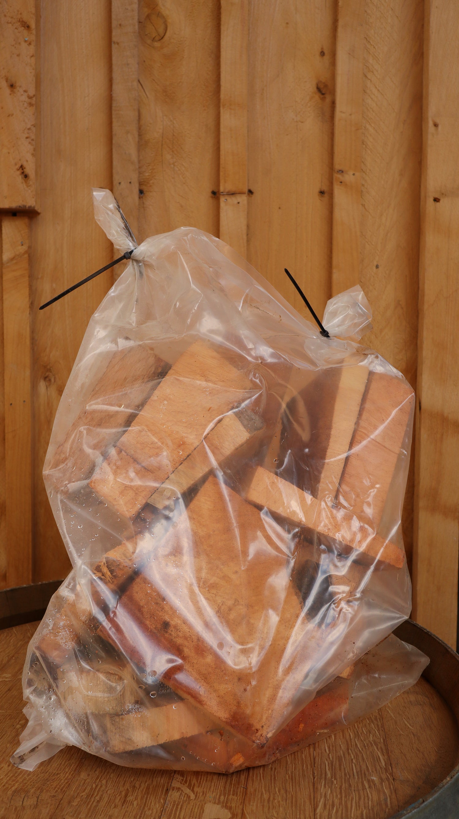A bag of wood on top of a wine barrel against a timber backdrop