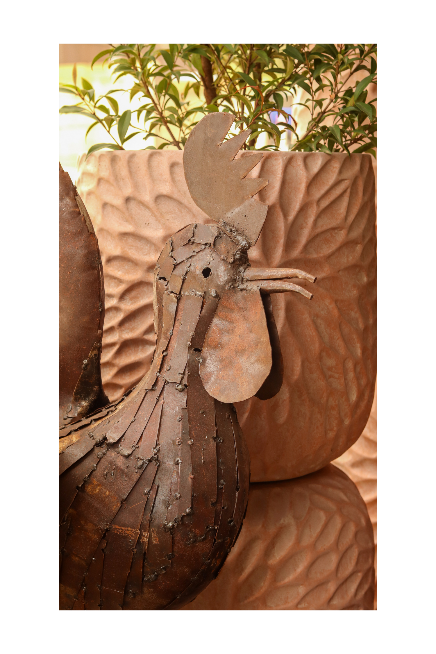A rusted metal sculpture of a rooster