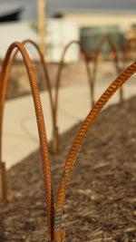 Rust-colored metal hoop in a garden on a blurred outdoor background